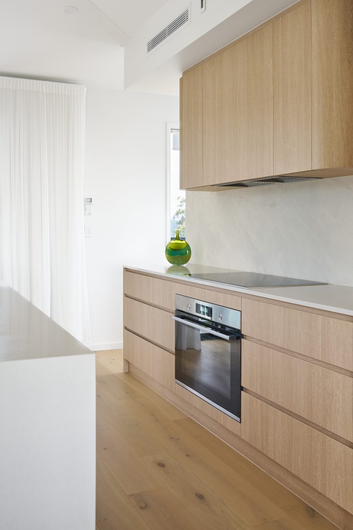 Modern kitchen with wooden cabinets and green vase