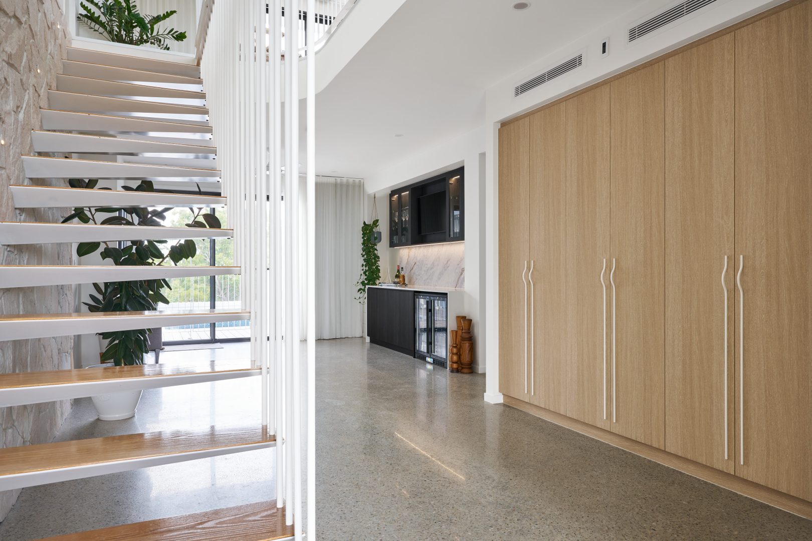 Modern interior with staircase and wooden cabinets.