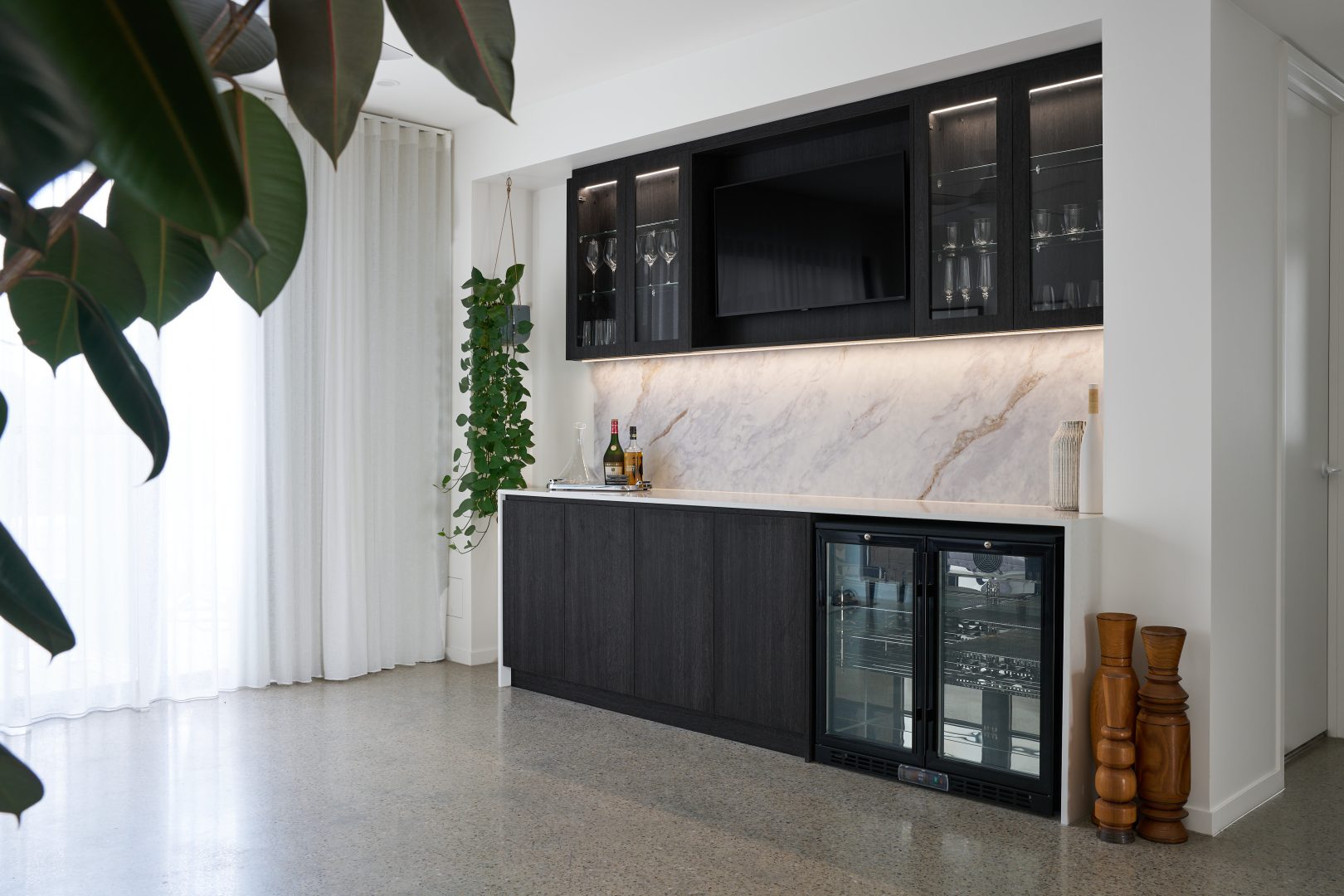 Modern kitchenette with bar counter and TV.