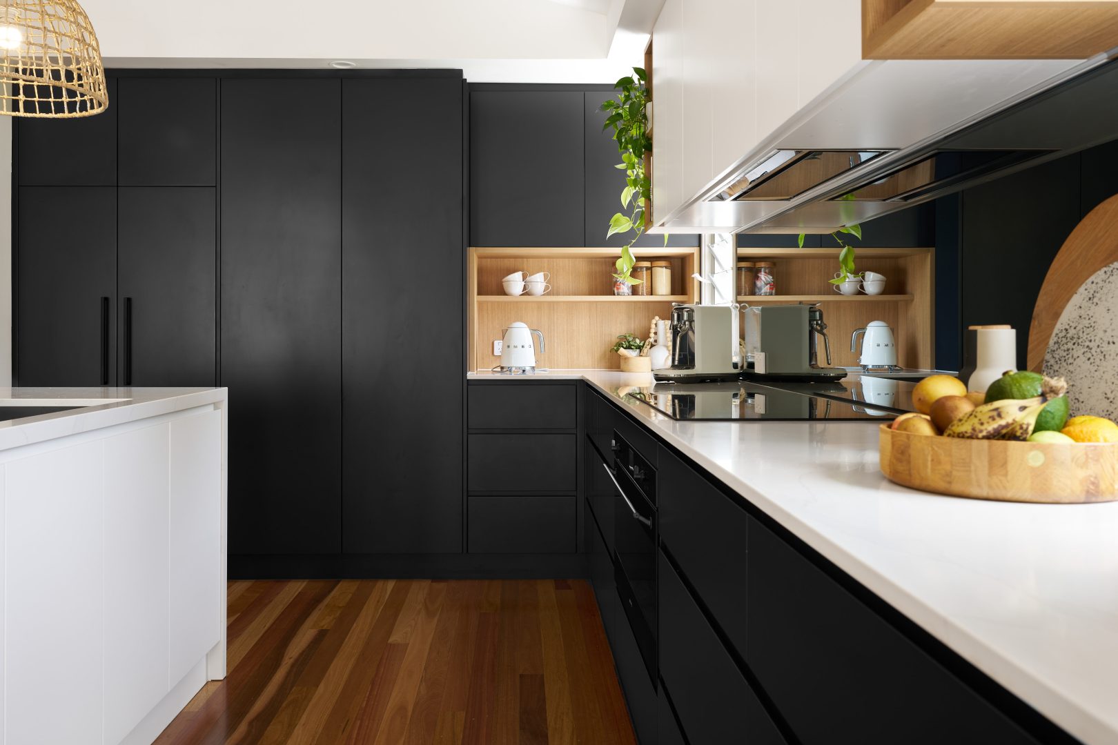 Modern kitchen with black cabinets and wooden accents.