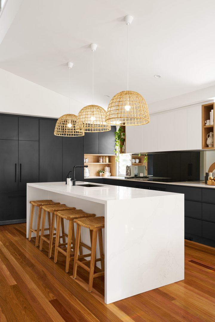 Modern kitchen with island and pendant lights.
