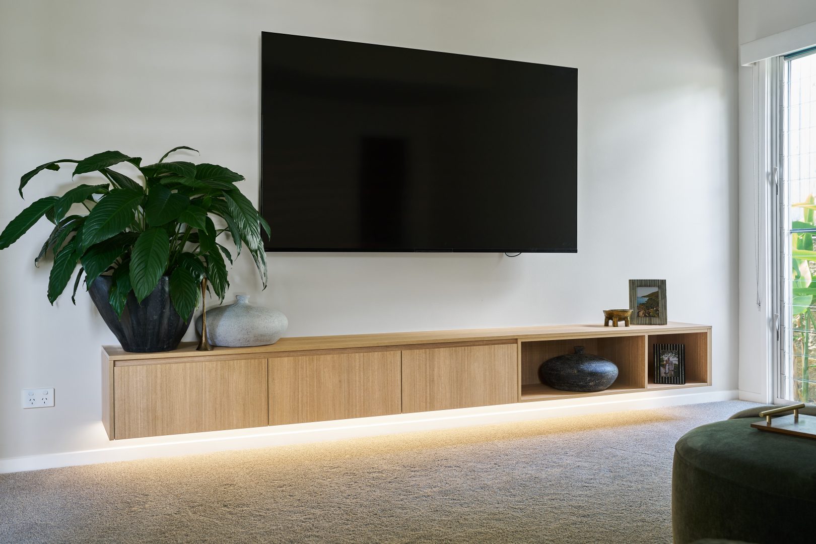 Modern living room with wall-mounted TV and plants