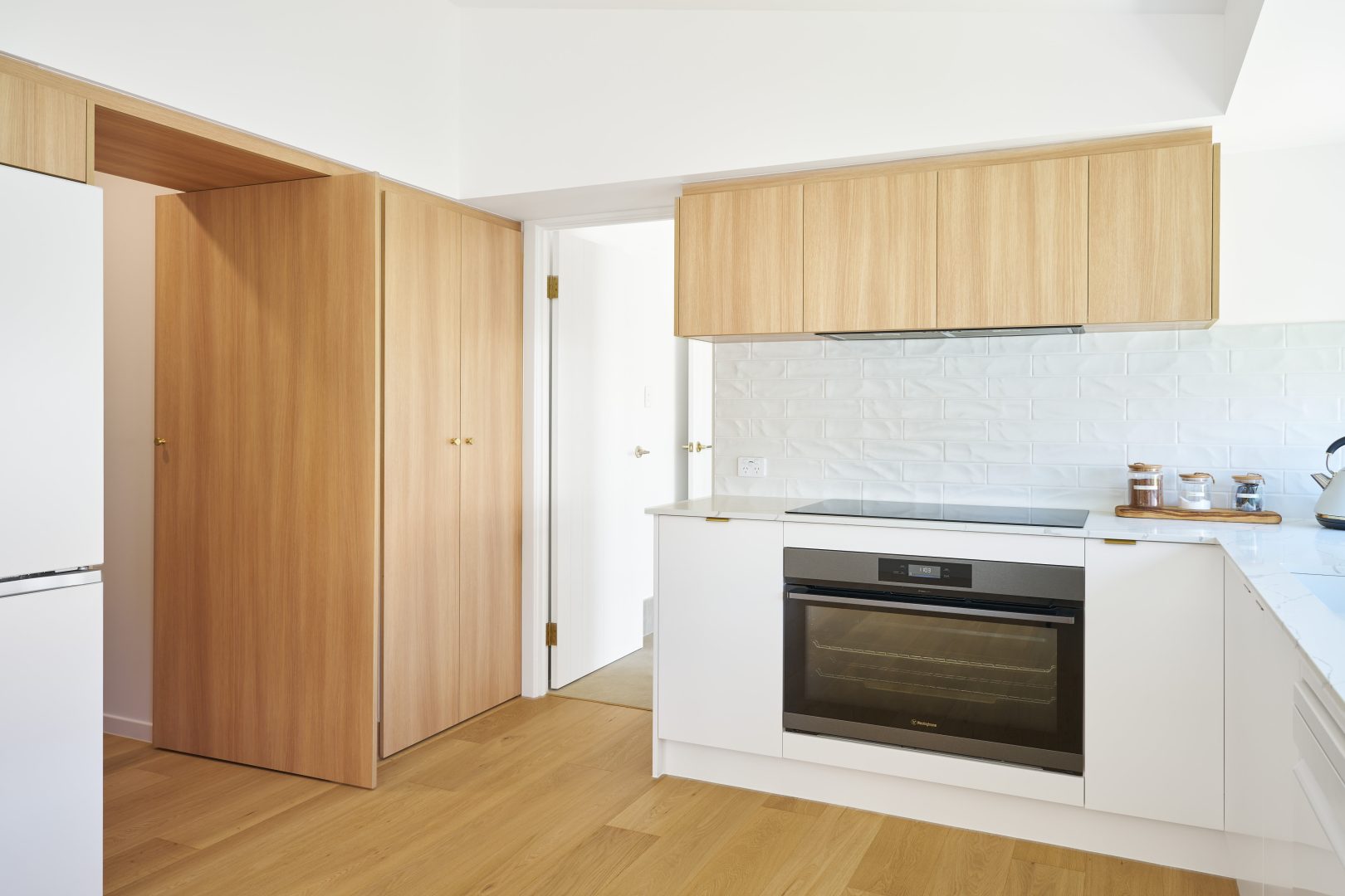 Modern kitchen with wooden cabinets and oven.