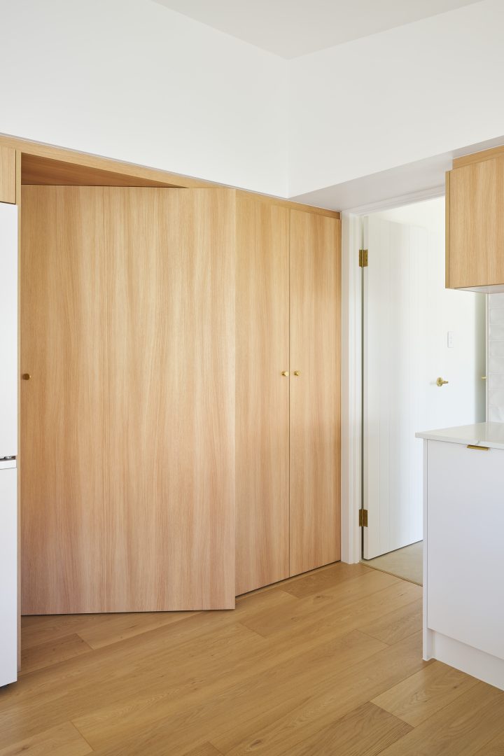 Modern kitchen with wooden cabinetry and floor.