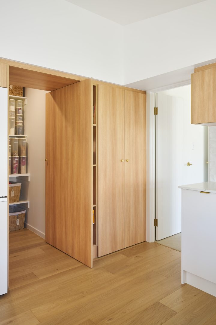 Pantry with wooden cabinets and organized shelves.