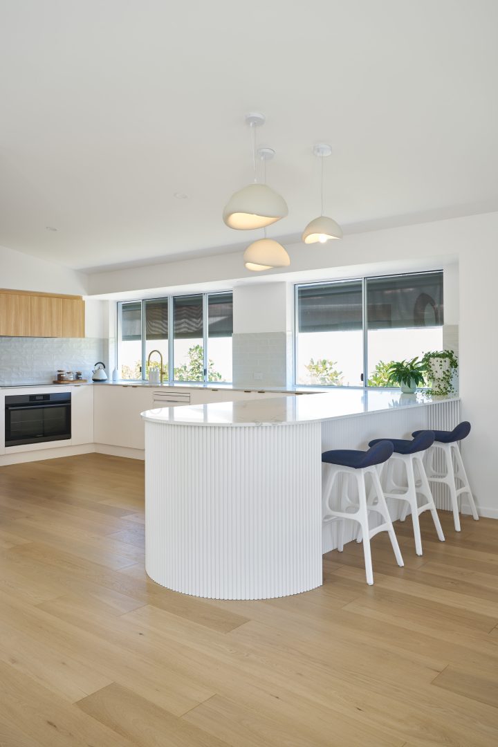Modern kitchen with island and three pendant lights.