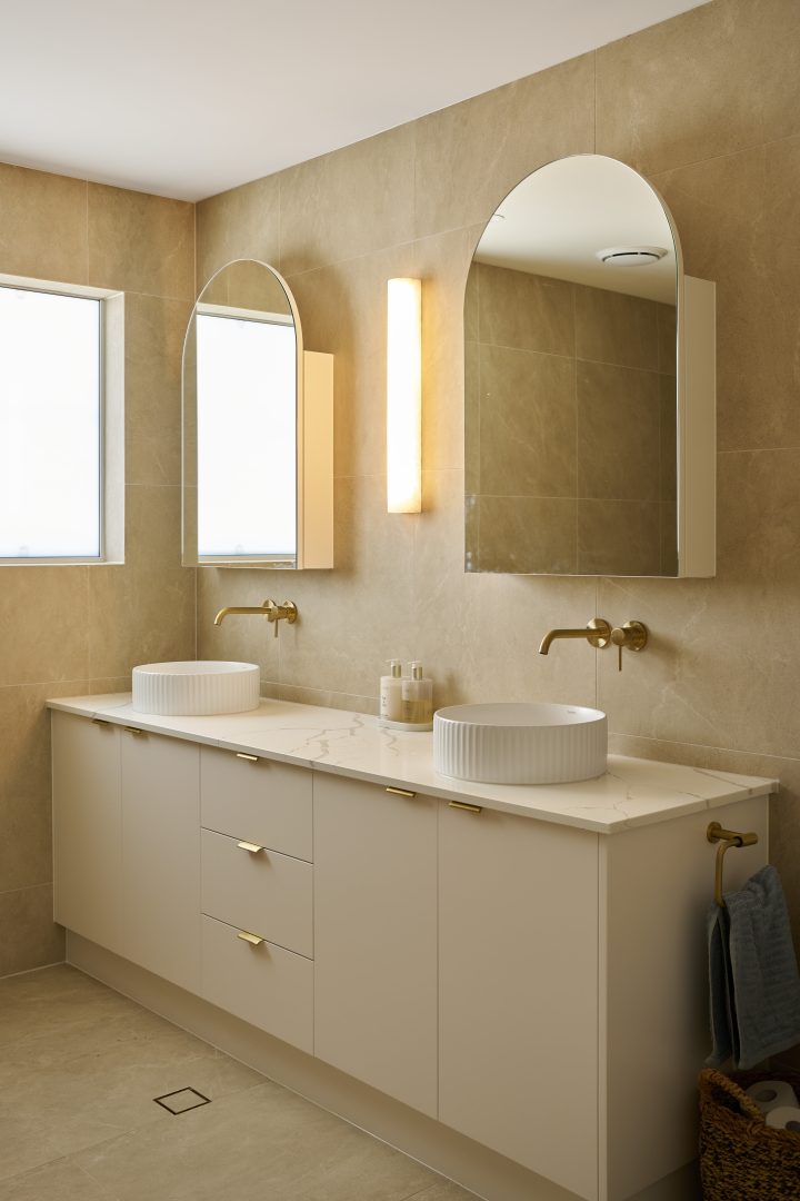 Modern bathroom with dual sinks and large mirrors.