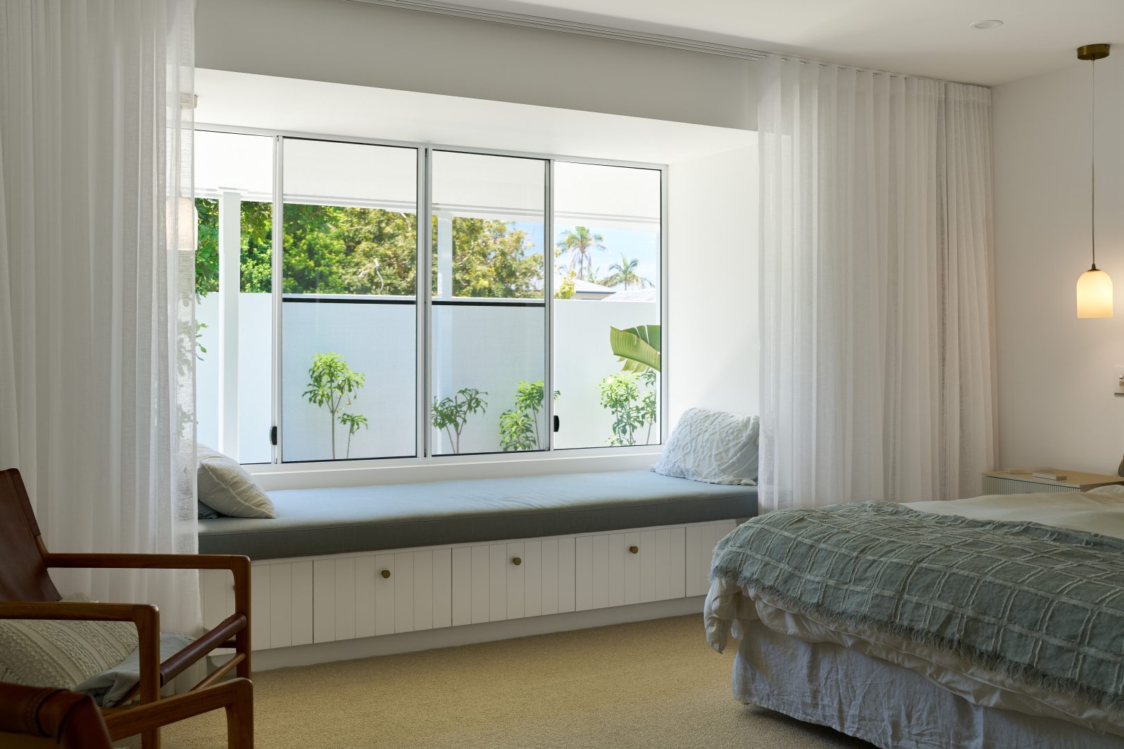 Cozy bedroom with window seat and natural light.