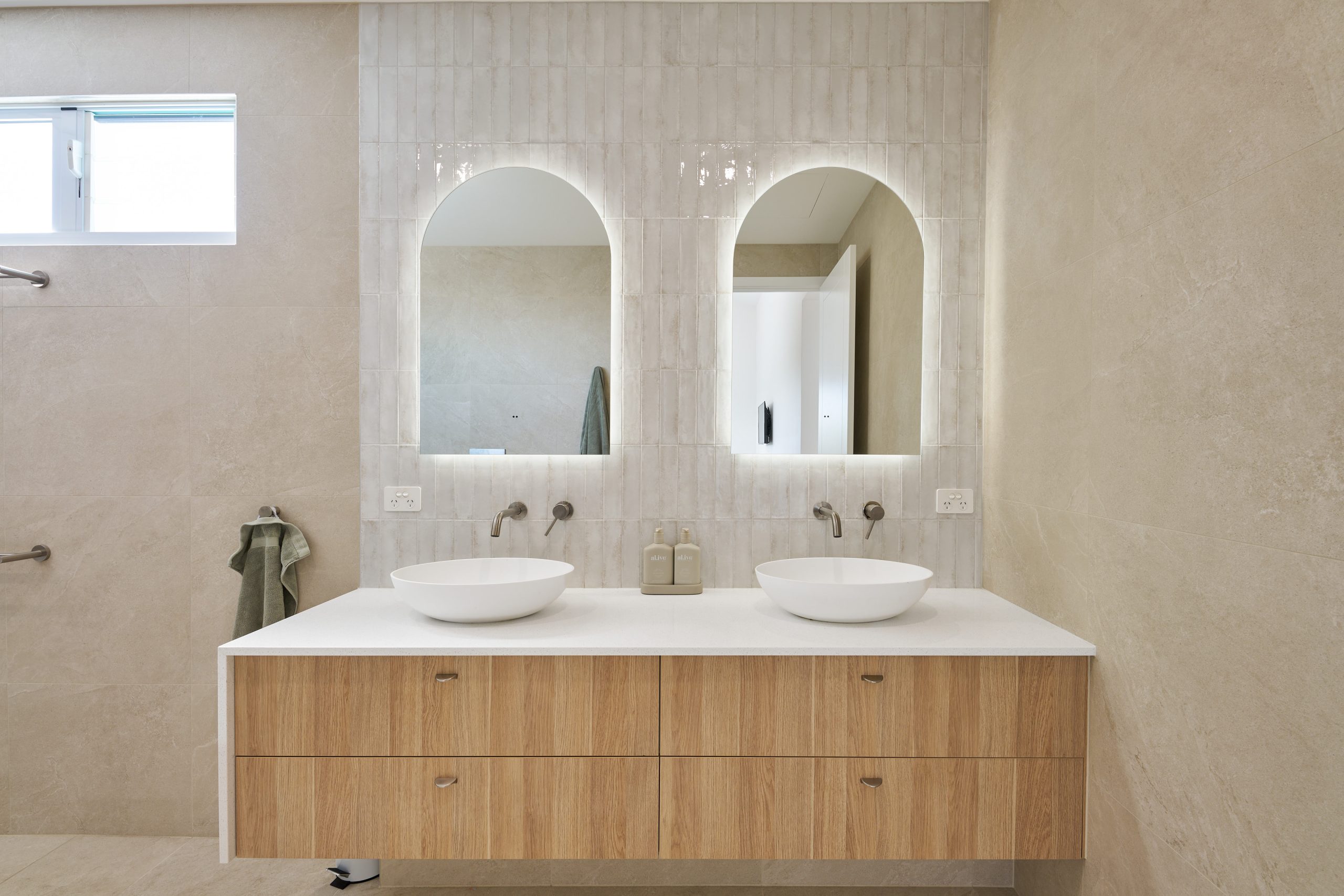 Modern bathroom with double sinks and mirrors.