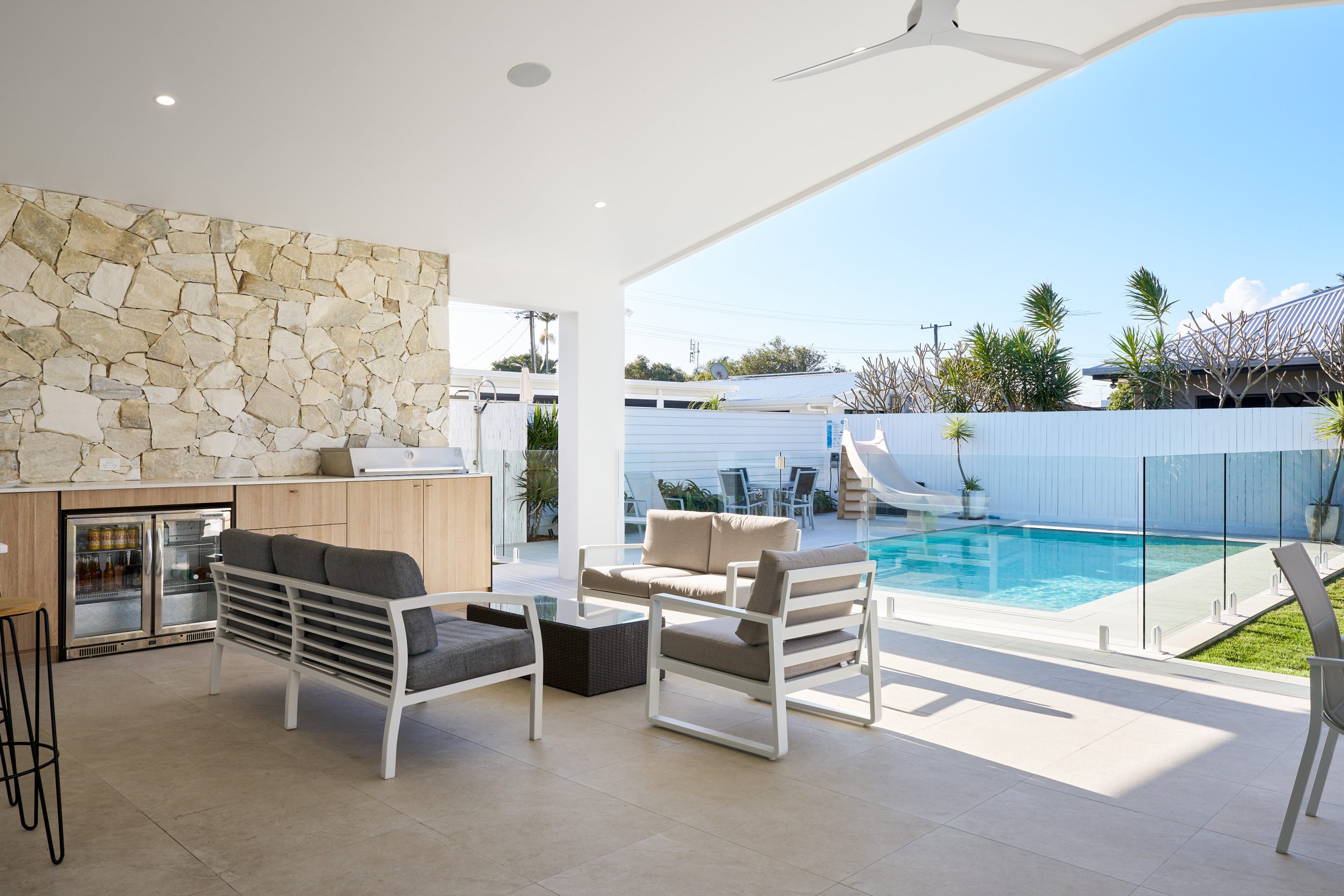 Modern patio with pool and outdoor seating area.